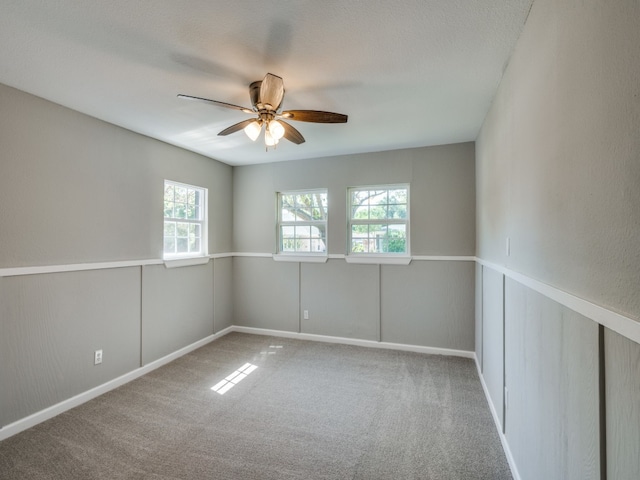 carpeted spare room featuring a textured ceiling and ceiling fan