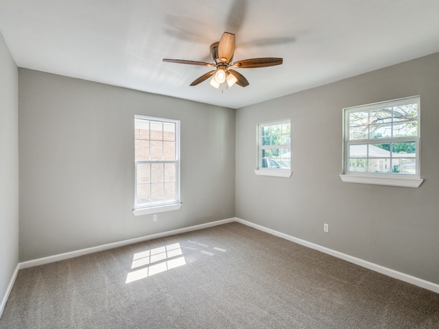 unfurnished room with carpet floors, a wealth of natural light, and ceiling fan