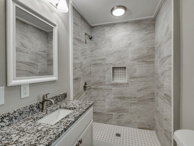 bathroom featuring tiled shower, vanity, and toilet