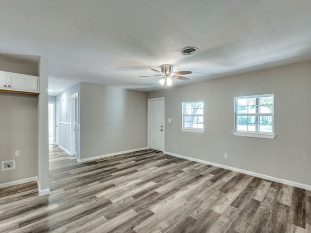 empty room featuring ceiling fan, a textured ceiling, and light hardwood / wood-style flooring