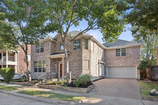 traditional-style home with brick siding, an attached garage, driveway, and fence