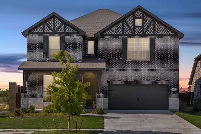 view of front of property with a yard and a garage