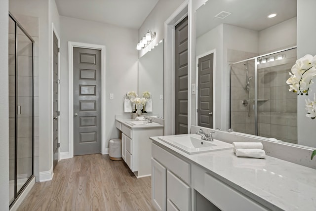 bathroom featuring a shower with shower door, vanity, and hardwood / wood-style flooring