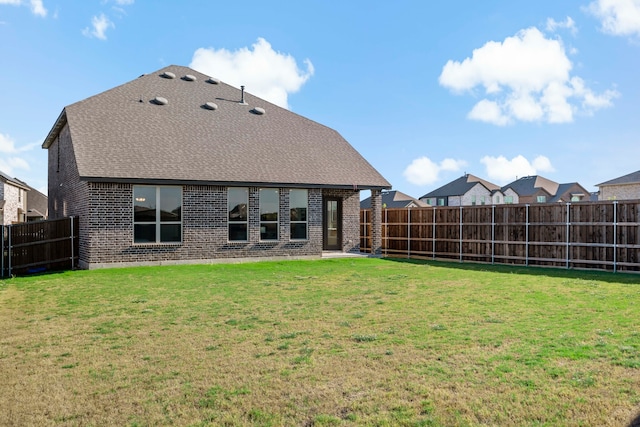 rear view of property featuring a lawn