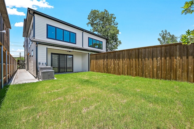 rear view of property with a lawn and central AC unit