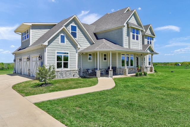 view of front of house featuring a garage, a front lawn, and covered porch