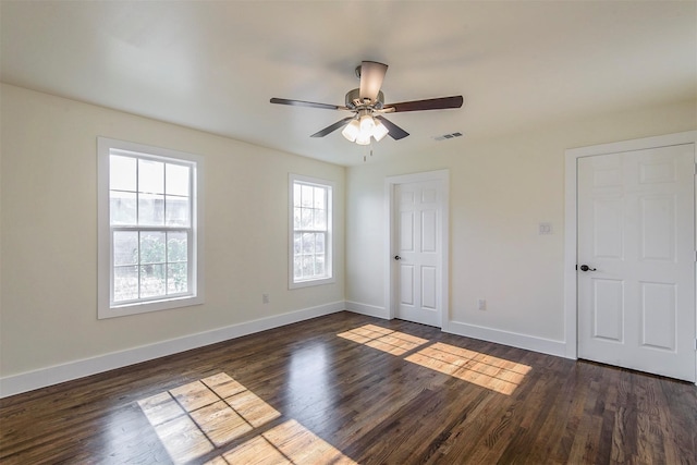 unfurnished room with ceiling fan and dark wood-type flooring