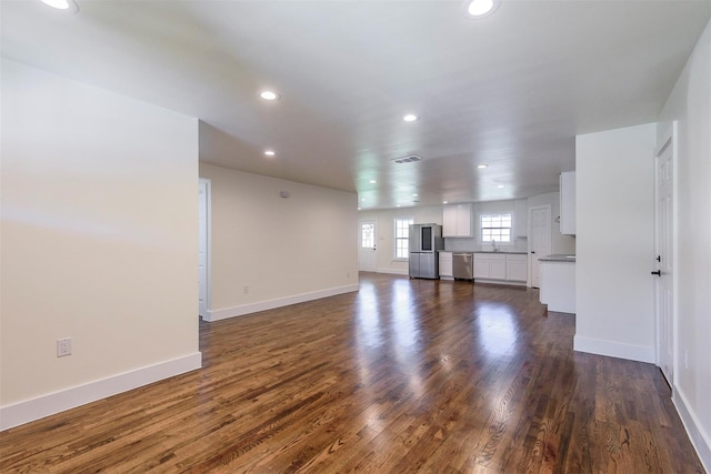 unfurnished living room featuring sink and dark hardwood / wood-style flooring