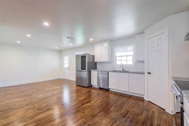 kitchen with sink, white cabinetry, stainless steel appliances, dark hardwood / wood-style floors, and decorative backsplash