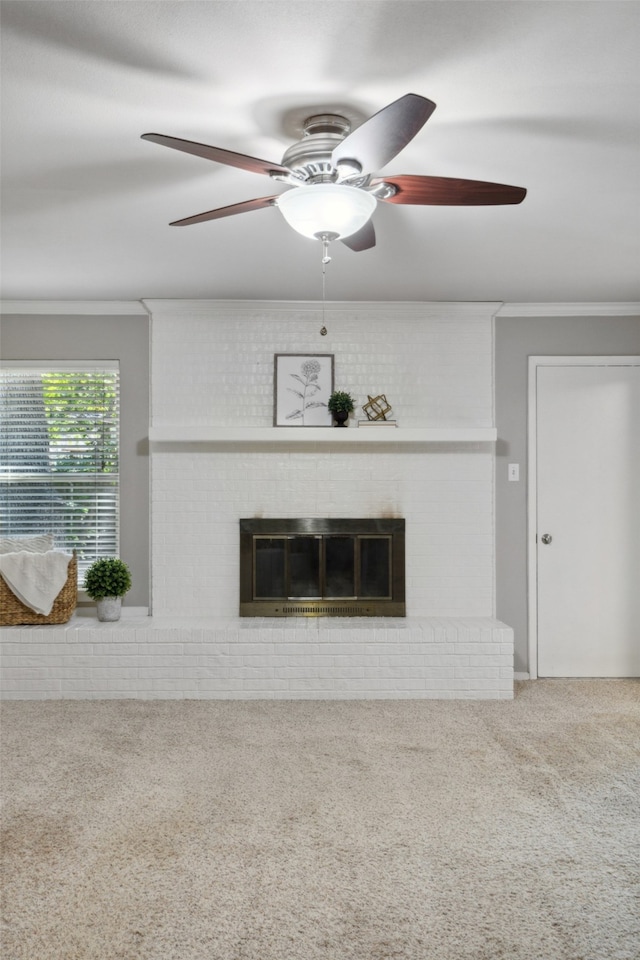 unfurnished living room with a fireplace, crown molding, ceiling fan, and carpet floors