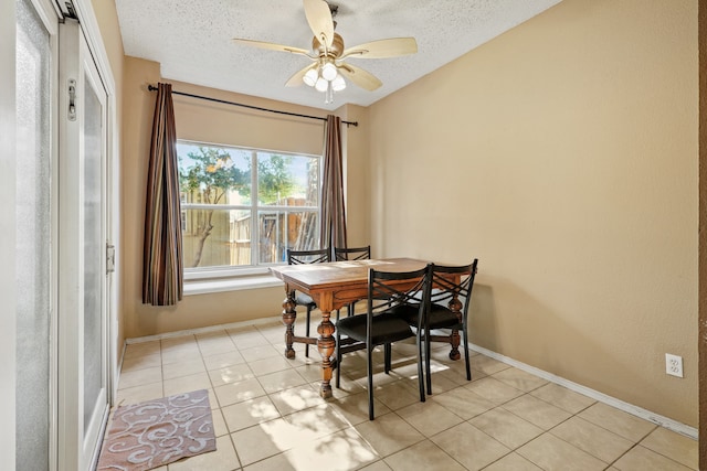 dining room featuring a textured ceiling, light tile patterned floors, and ceiling fan