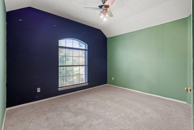 empty room featuring lofted ceiling, carpet, a textured ceiling, and ceiling fan