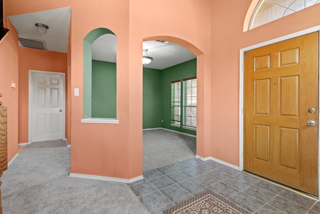 carpeted entrance foyer with a textured ceiling