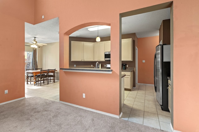 kitchen featuring light carpet, pendant lighting, a textured ceiling, and appliances with stainless steel finishes