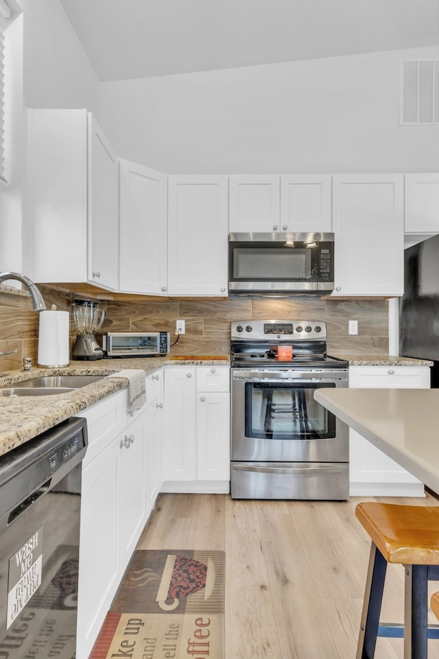 kitchen featuring white cabinets, light hardwood / wood-style floors, stainless steel appliances, and sink