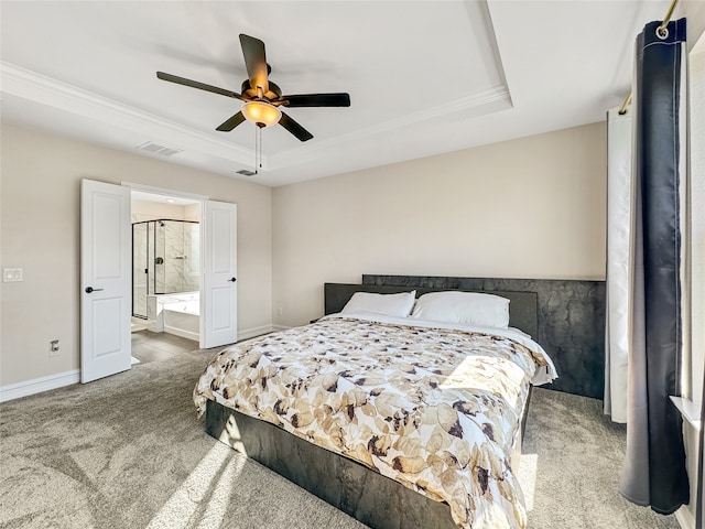 carpeted bedroom with ceiling fan, a raised ceiling, ensuite bath, and ornamental molding