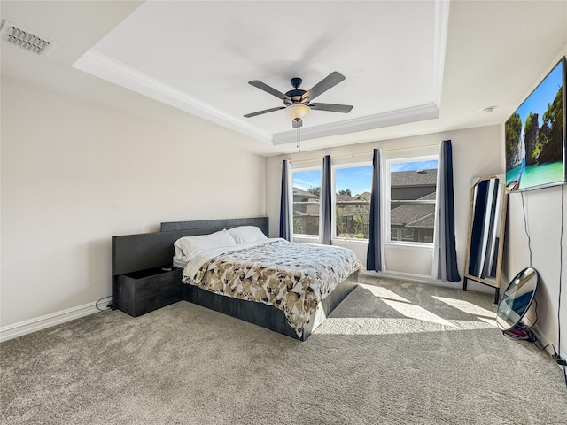 carpeted bedroom with ornamental molding, ceiling fan, and a raised ceiling