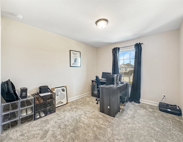 carpeted home office featuring a textured ceiling