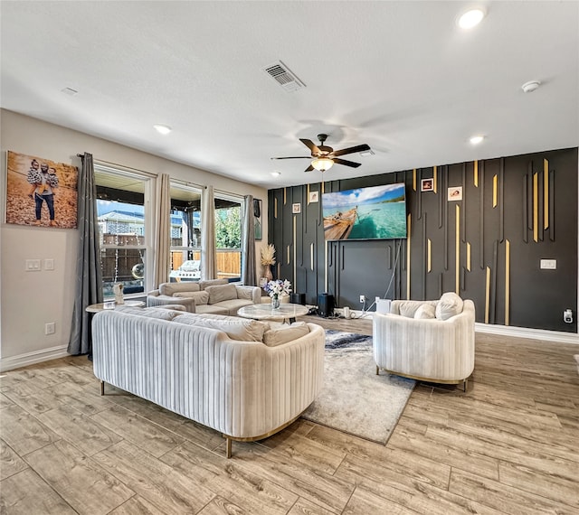 living room featuring ceiling fan and light hardwood / wood-style flooring