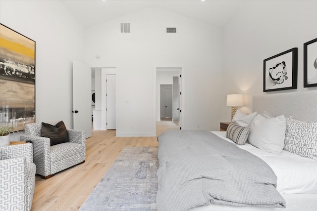 bedroom featuring light hardwood / wood-style flooring and high vaulted ceiling