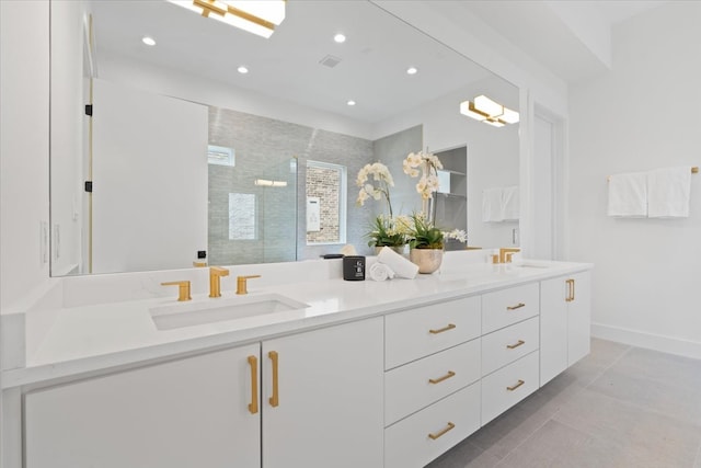 bathroom with a tile shower, tile patterned flooring, and vanity