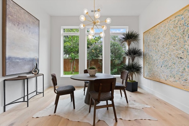 dining area with plenty of natural light, a chandelier, and light wood-type flooring