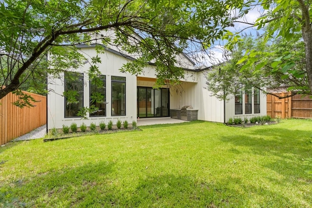 rear view of house featuring a lawn and a patio area