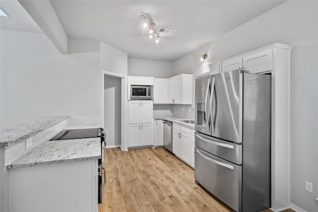 kitchen featuring kitchen peninsula, appliances with stainless steel finishes, white cabinetry, light stone countertops, and light wood-type flooring