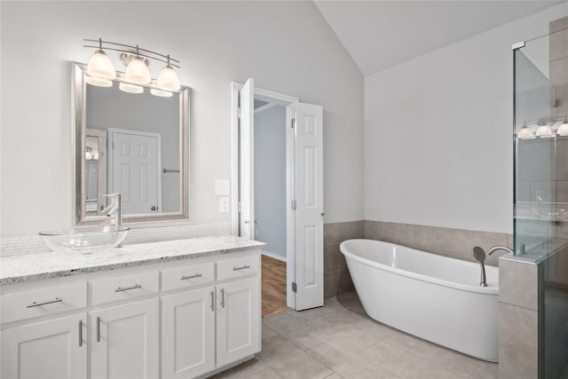 bathroom featuring vanity, tile patterned floors, vaulted ceiling, and independent shower and bath