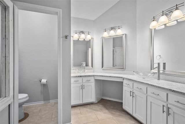 bathroom with vanity, toilet, and tile patterned flooring