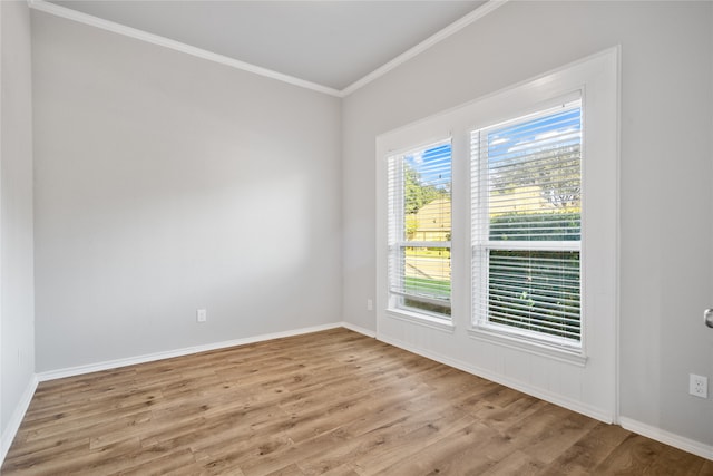 spare room featuring crown molding and light wood-type flooring