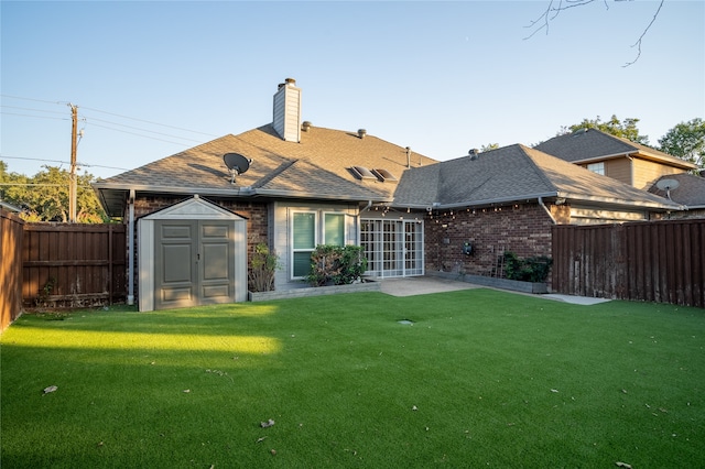 back of house with a yard, a patio area, and a shed