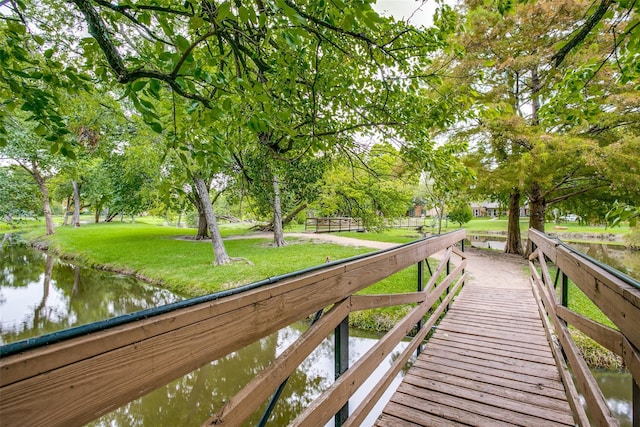 view of home's community with a water view and a lawn