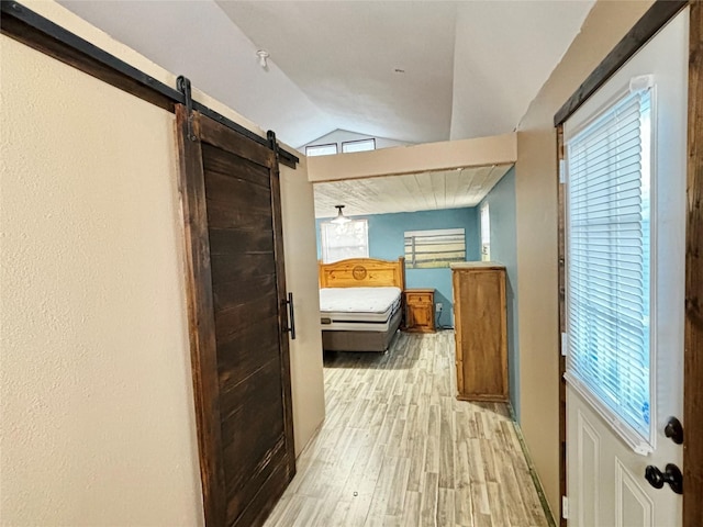 hall featuring vaulted ceiling and light hardwood / wood-style flooring