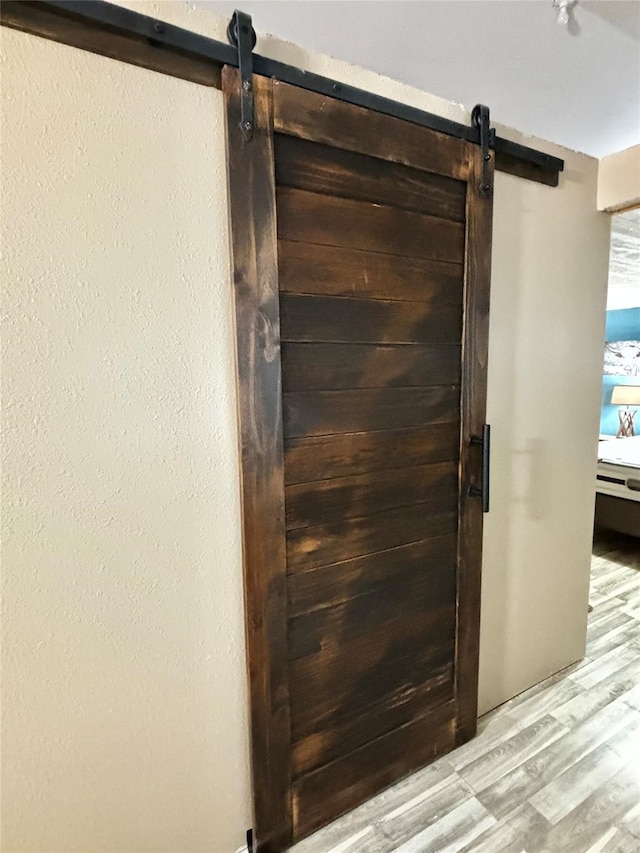 interior details with a barn door and hardwood / wood-style floors