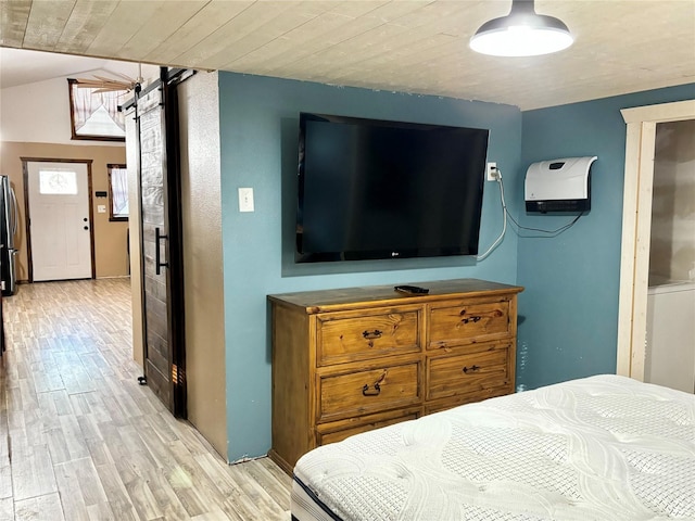 bedroom featuring a barn door, lofted ceiling, wood ceiling, and light hardwood / wood-style flooring