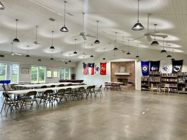 dining space featuring ceiling fan, a towering ceiling, and concrete floors