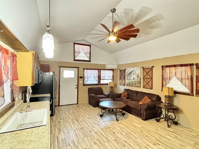 living room with ceiling fan, light wood-type flooring, lofted ceiling, and a healthy amount of sunlight