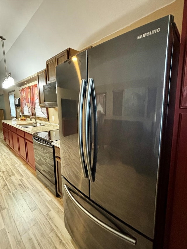 kitchen with sink, decorative light fixtures, stainless steel appliances, light wood-type flooring, and vaulted ceiling