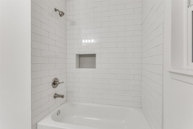 bathroom featuring tiled shower / bath