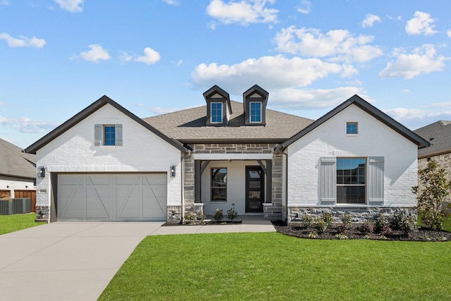 view of front of property featuring central air condition unit, driveway, brick siding, and a front yard