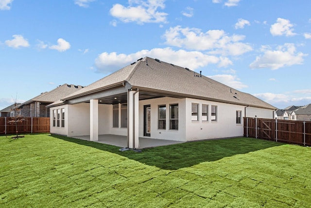 rear view of property with a yard, a patio area, a fenced backyard, and a shingled roof