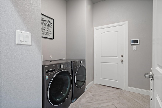 laundry area featuring light parquet floors and washer and clothes dryer