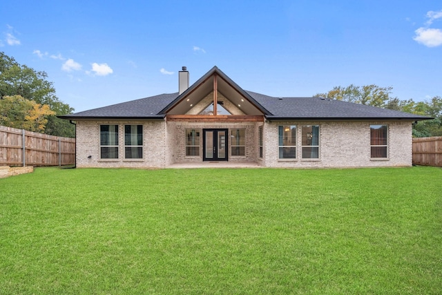 back of property featuring a yard and french doors