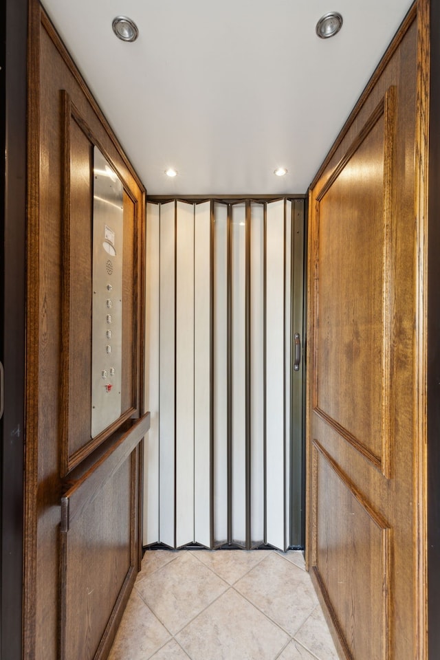 hall with elevator and light tile patterned floors