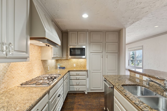 kitchen featuring custom range hood, sink, stainless steel appliances, dark hardwood / wood-style floors, and a textured ceiling