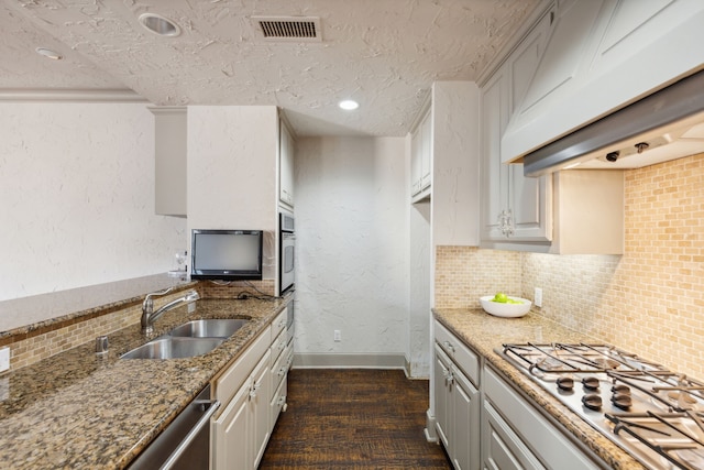 kitchen featuring white cabinets, dark stone countertops, premium range hood, dark hardwood / wood-style flooring, and appliances with stainless steel finishes