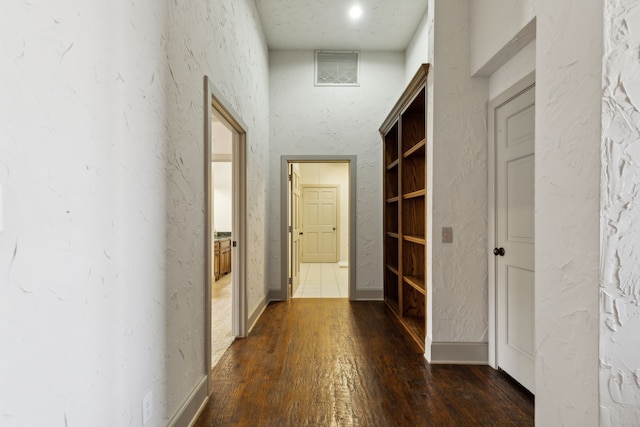 corridor with dark hardwood / wood-style flooring