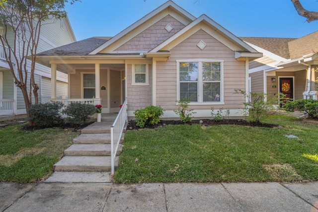 bungalow-style home with a front yard and covered porch