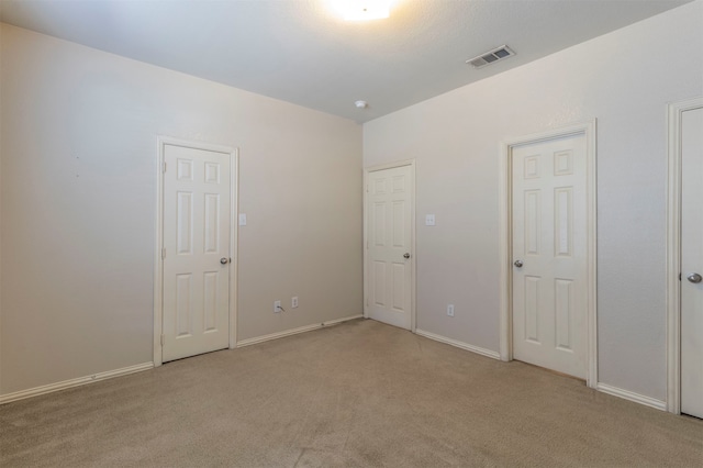 unfurnished bedroom with light colored carpet